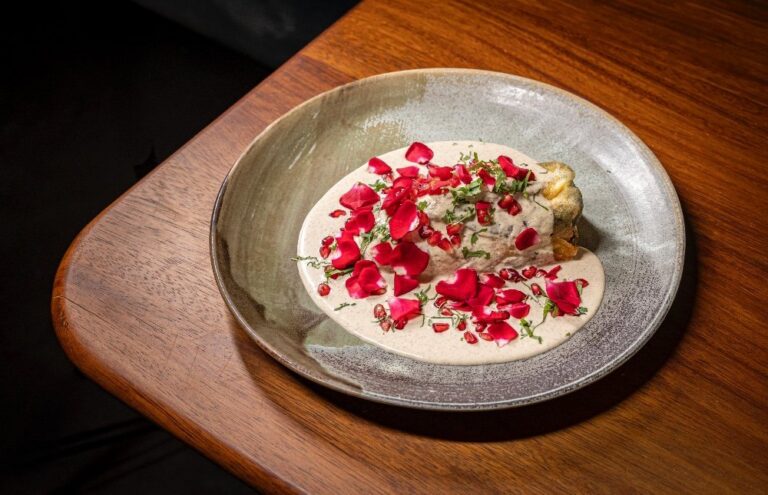 Chiles en nogada decorados con pétalos de rosa y granada
