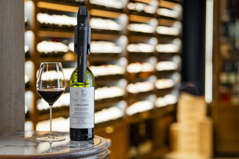 Botella de vino Vega Sicilia Unico 2016 con copas en un bar