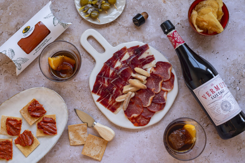 Selección de ibéricos y vermut en una mesa de aperitivo