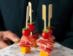 Pinchos de jamón ibérico con tomate cherry y queso en presentación atractiva