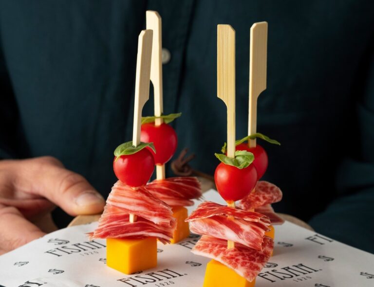 Pinchos de jamón ibérico con tomate cherry y queso en presentación atractiva