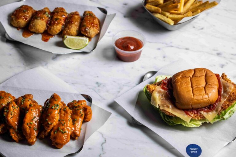 Plato de pollo crujiente y alitas con salsas en un restaurante