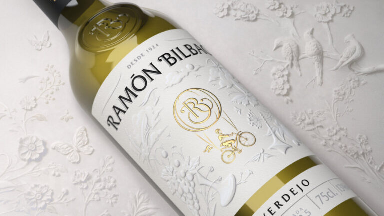 Botella de vino blanco Ramón Bilbao Verdejo sobre fondo decorativo