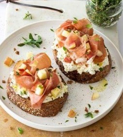 Tostadas de queso de cabra con speck y manzana en un plato