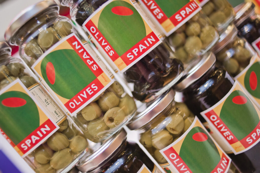 Tarros de aceitunas verdes y negras con etiquetas que indican aceitunas de España