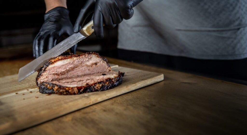 Corte de brisket de vacuno Angus ahumado en una tabla de madera