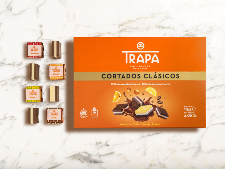 Caja naranja de Cortados Clásicos Trapa junto a varios bombones sobre fondo claro.