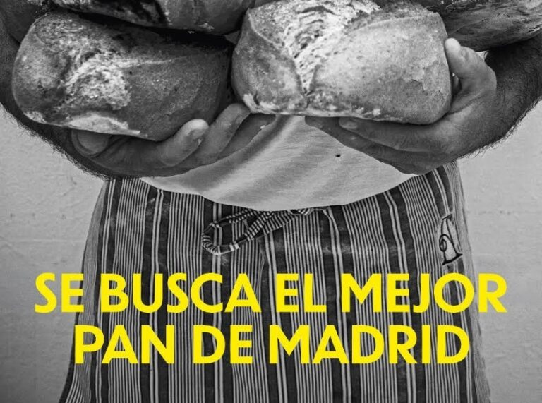 Cartel de dos hogazas sostenidas por una persona con mensaje sobre el mejor pan de Madrid
