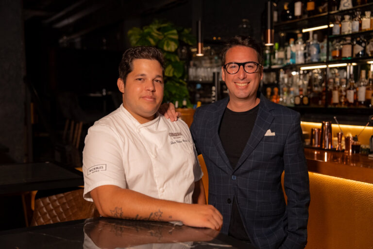 El chef Liván Valdés y Toni Ramírez posan frente a la barra de un restaurante.