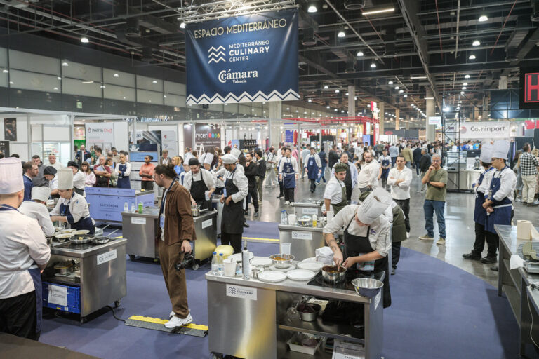 Cocineros trabajan en puestos de cocina durante una feria gastronómica concurrida