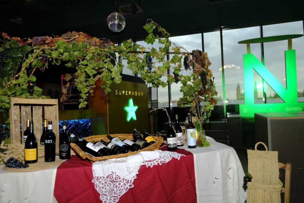 Mesa con botellas de vino y decoración de uvas en un evento