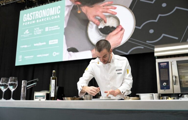 Una persona con chaqueta blanca prepara un plato en un mostrador del Gastronomic Forum Barcelona