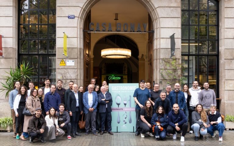 Grupo de personas posa junto a un cartel de Gastronomic Forum Barcelona frente a Casa Bonay.