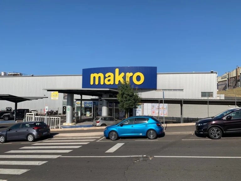 Fachada del centro Makro en Adeje, Tenerife, con vehículos estacionados.