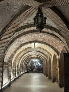 Interior de un pasadizo abovedado con arcos de ladrillo y piedra