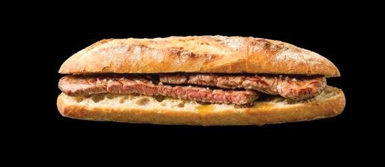 Bocadillo alargado de pan con relleno de carne sobre fondo negro