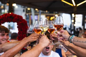 Varias personas brindan con copas de vino Rioja en un local.