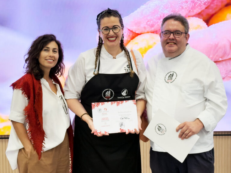Tres personas posan con diplomas; la persona central lleva un delantal de Tatel.