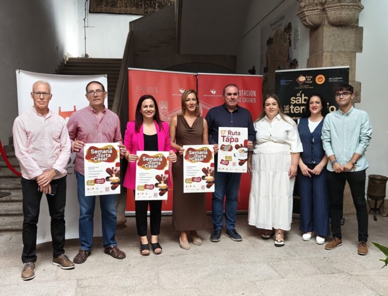 Grupo de personas presentando la Semana de la Torta del Casar con carteles informativos.