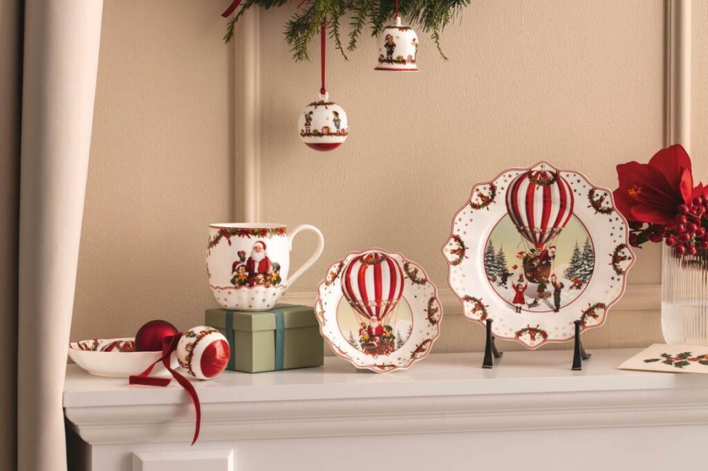 Vajilla navideña decorada con globos aerostáticos junto a adornos y flores rojas